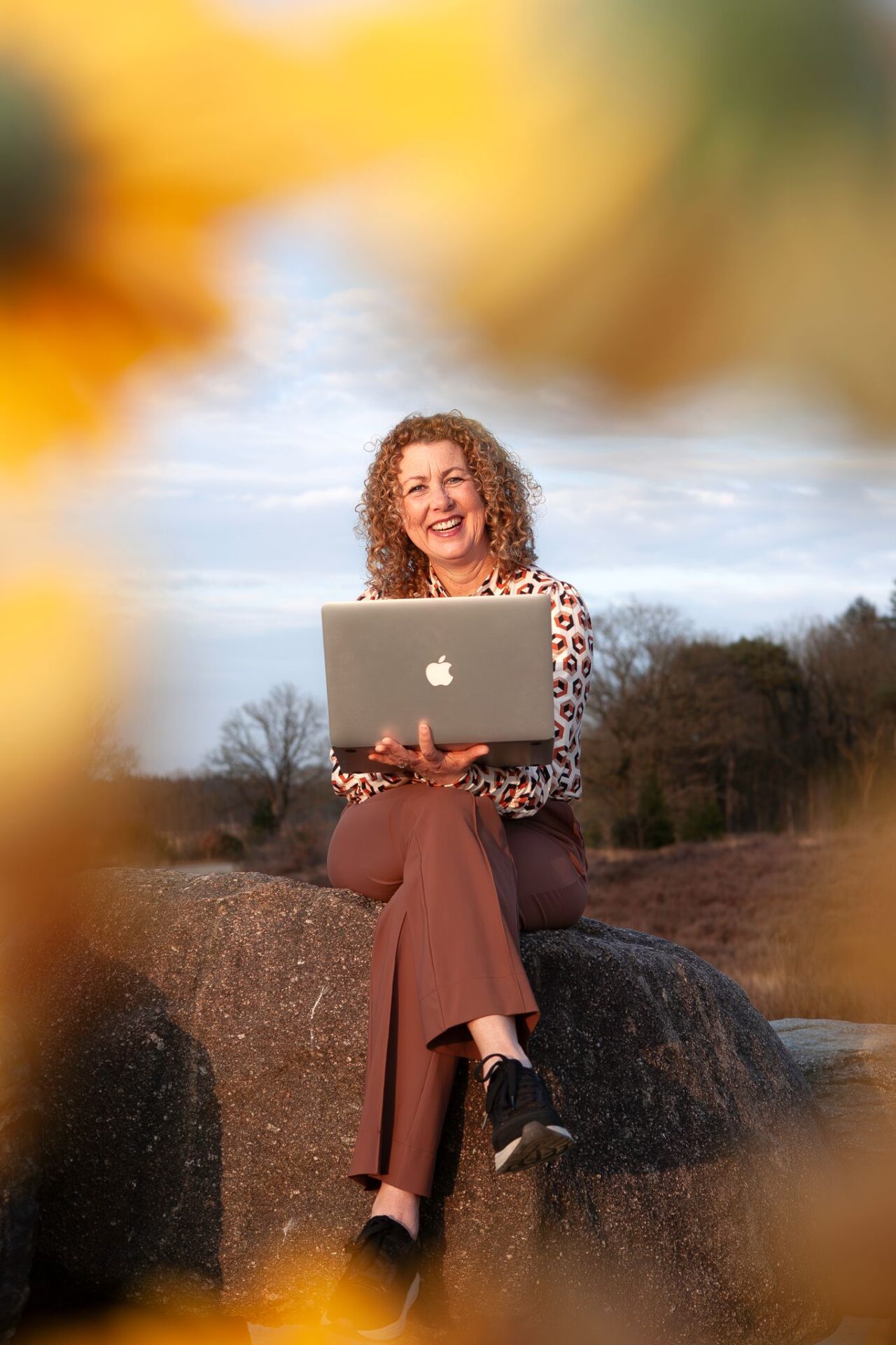 Bizzy Bee Christie met laptop op hunnebed en bloemen