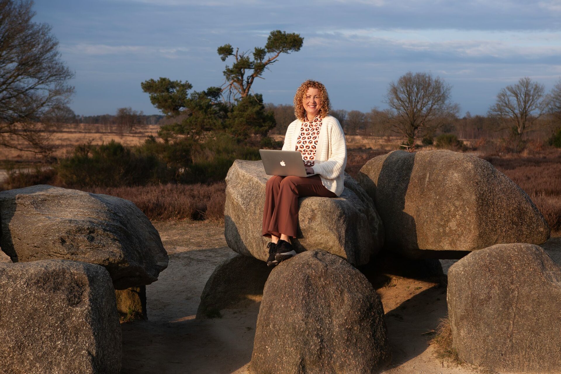 Christie de Lint met laptop op hunnebed